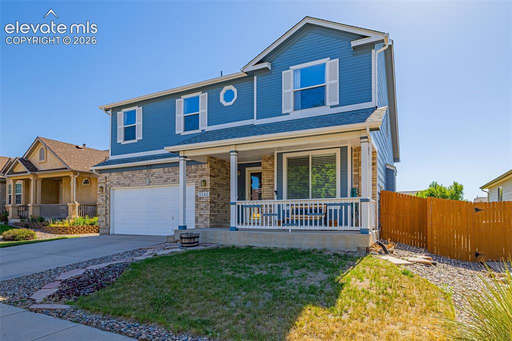 Image 3 of 42: Two-story residence featuring blue siding and stone veneer accents