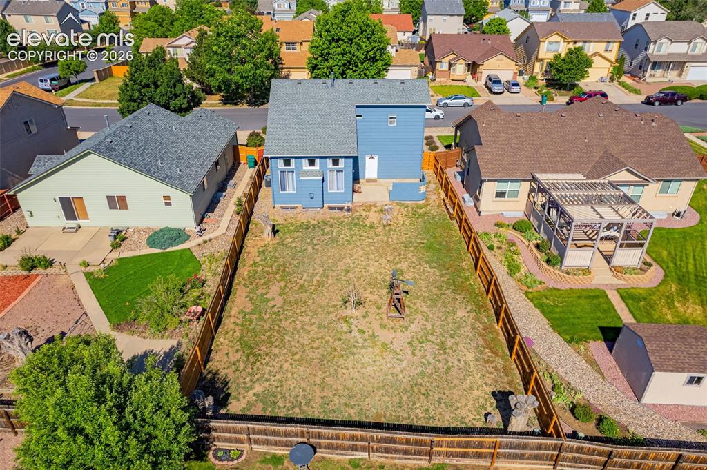 Image 34 of 42: Expansive backyard featuring a partial wood privacy fence, a detached stora