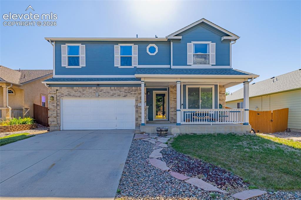 Image 4 of 42: Two-story residence featuring blue siding and a partial brick facade