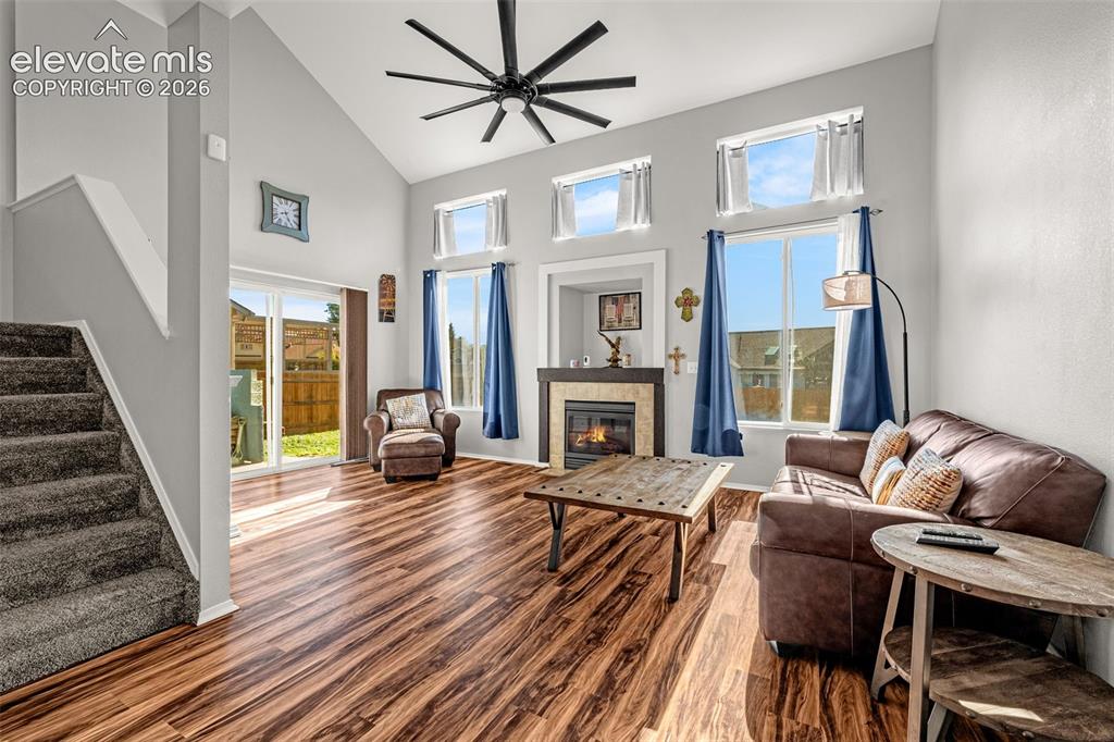 Image 6 of 42: Vaulted living space featuring wood-finish flooring, a fireplace with stone