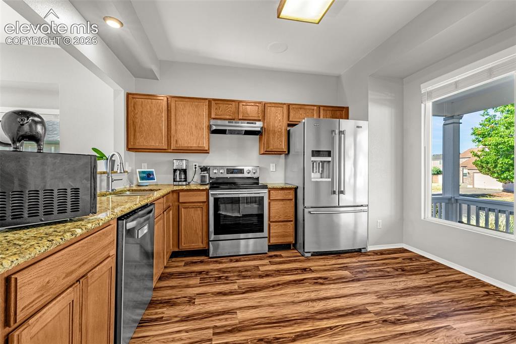 Image 9 of 42: Kitchen featuring wood-finish flooring, light wood cabinetry, stainless ste
