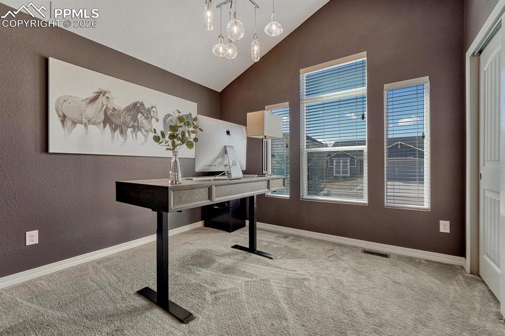 Image 13 of 50: Main Level Bedroom #1 (currently being used as an office) has neutral carpe