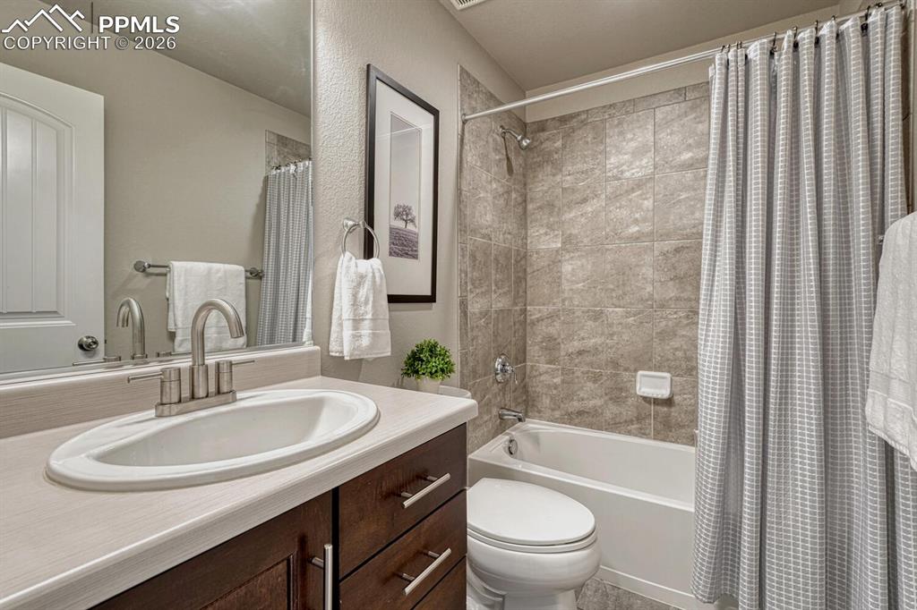 Image 15 of 50: Main Level Full Bathroom with comfort height vanity, mirror, and tiled tub/