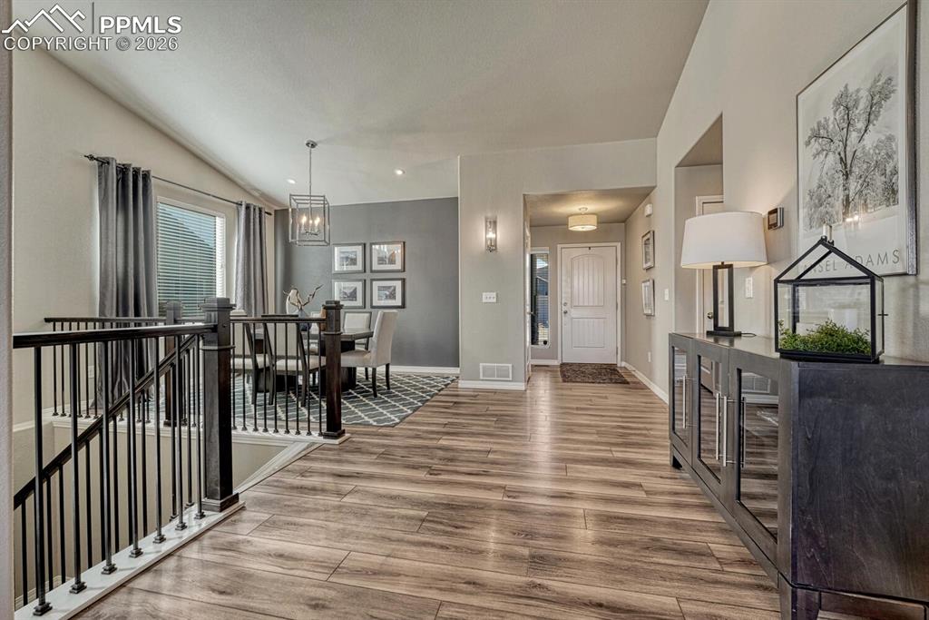 Image 31 of 50: View of the Front Entry and Formal Dining Room with iron rails to the Finis