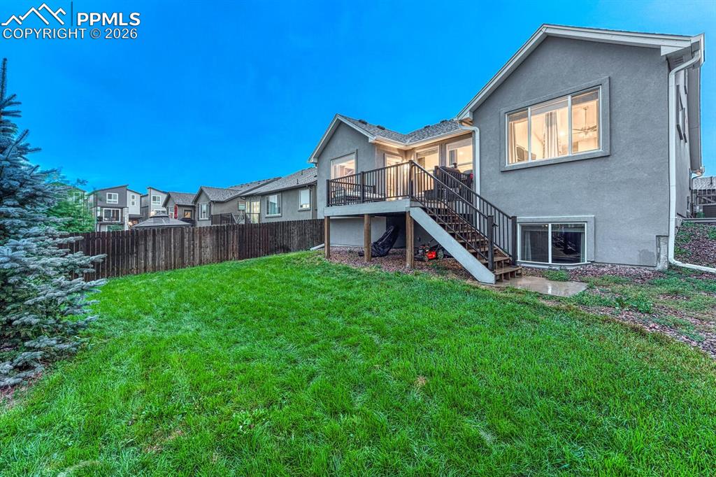 Image 46 of 50: Rear view of house and fenced backyard.