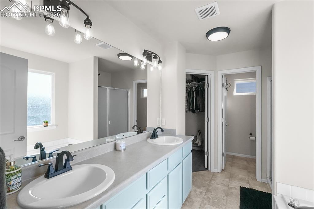 Image 13 of 25: Double vanity with walk in closet.