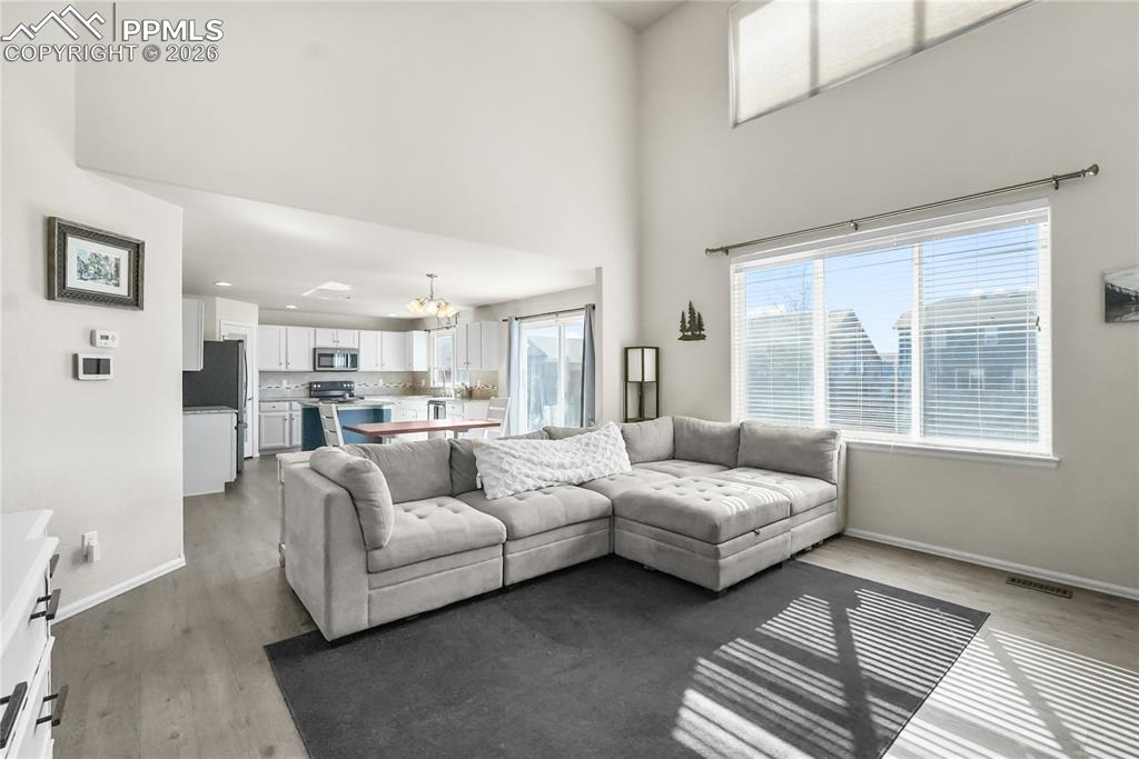 Image 6 of 25: Living room with vaulted ceilings and natural light.