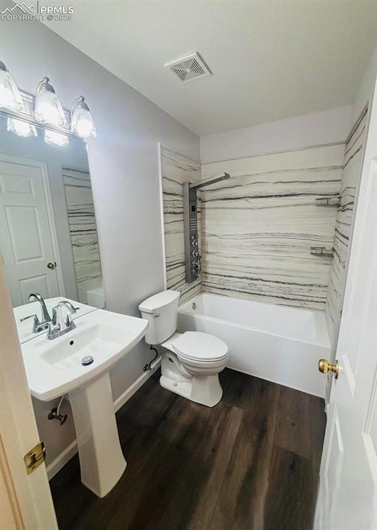 Image 10 of 18: Full bath with bathing tub / shower combination and dark wood finished floo