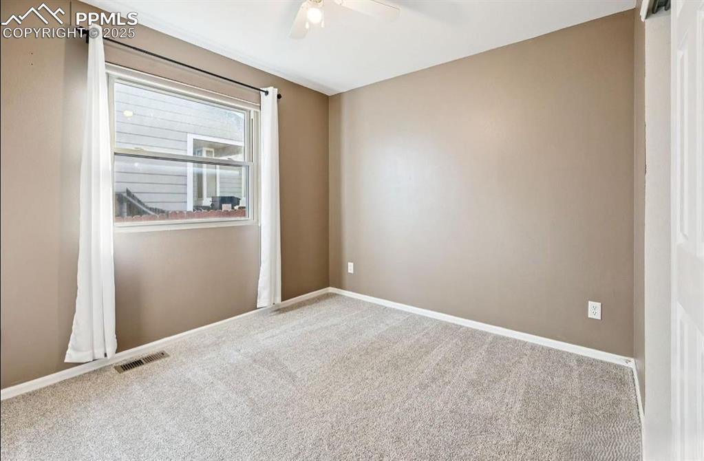 Image 11 of 18: Spare room with carpet flooring and ceiling fan