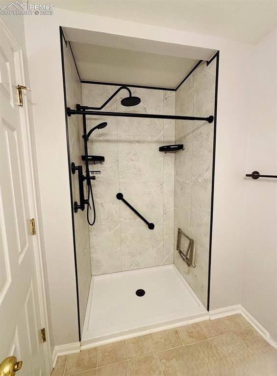Image 14 of 18: Full bath with a shower stall and light tile patterned floors