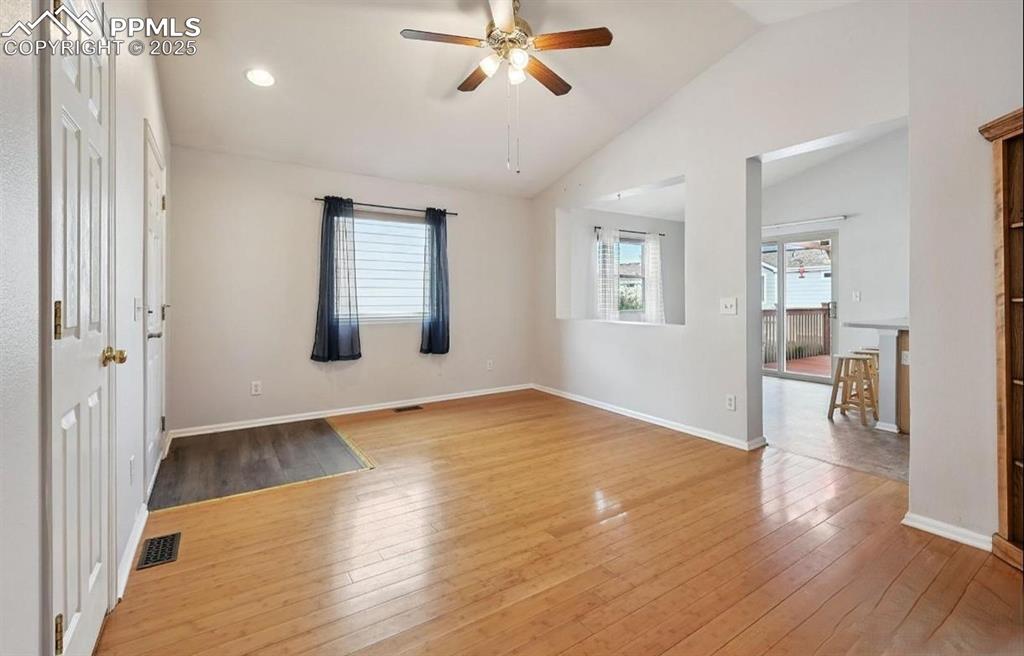 Image 6 of 18: Spare room with vaulted ceiling, healthy amount of natural light, light woo