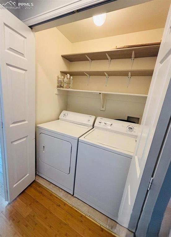 Image 9 of 18: Laundry area featuring light wood finished floors and washing machine and c
