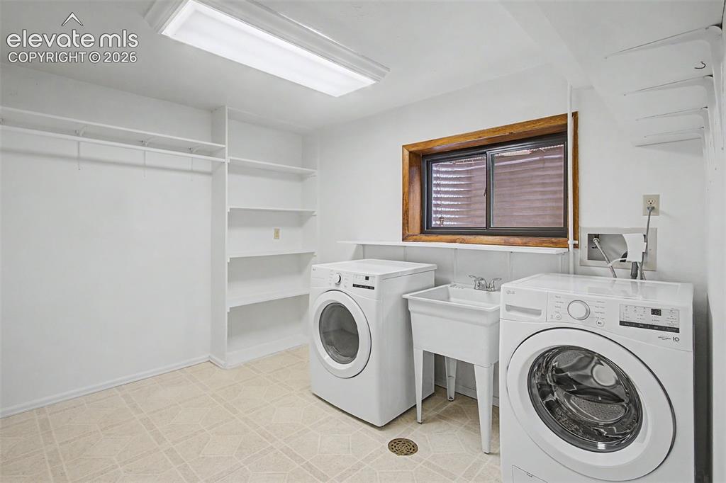 Image 40 of 49: Laundry with utility sink and storage.