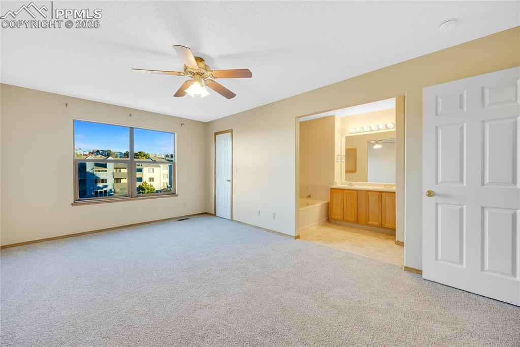 Image 14 of 32: Unfurnished bedroom featuring light carpet, connected bathroom, and a ceili