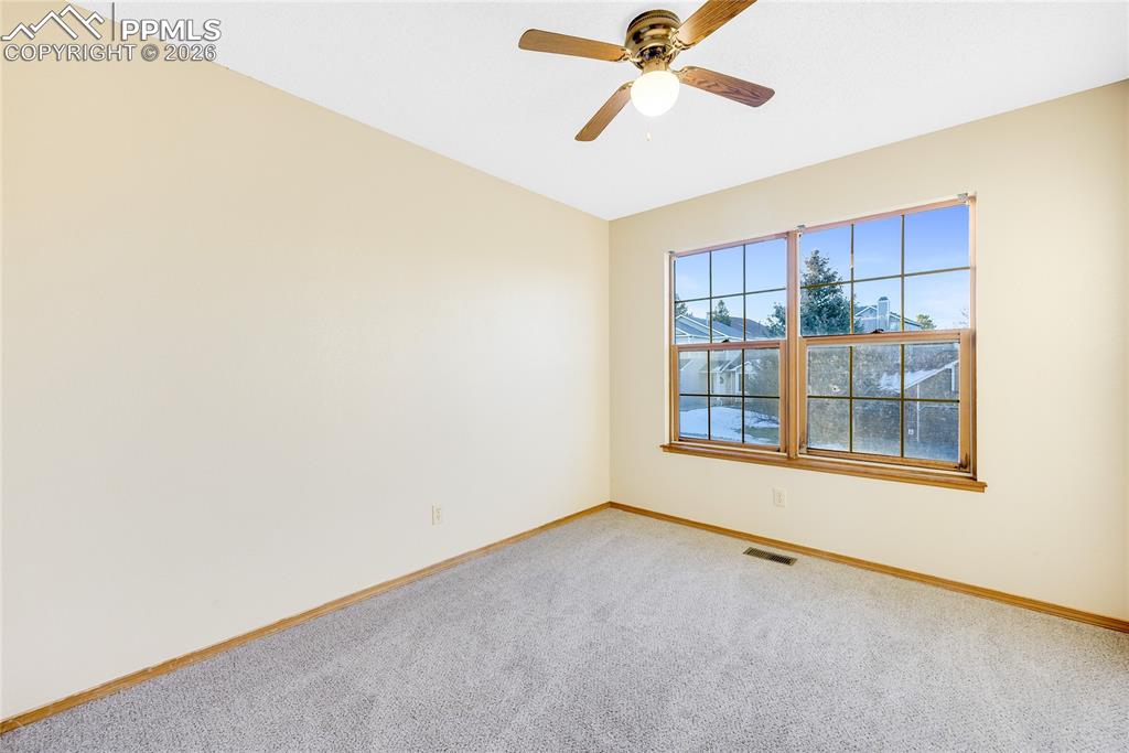 Image 16 of 32: Spare room featuring carpet and a ceiling fan