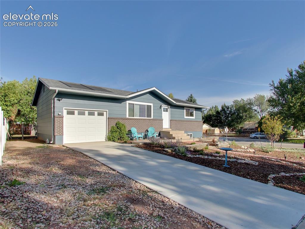 Image 1 of 32: Modern ranch-style home featuring a covered entry, attached garage, solar p
