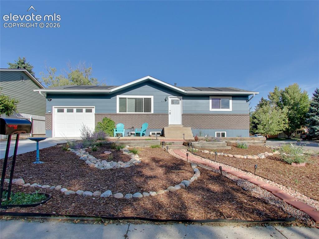 Image 28 of 32: Split-level home featuring blue siding and brick veneer