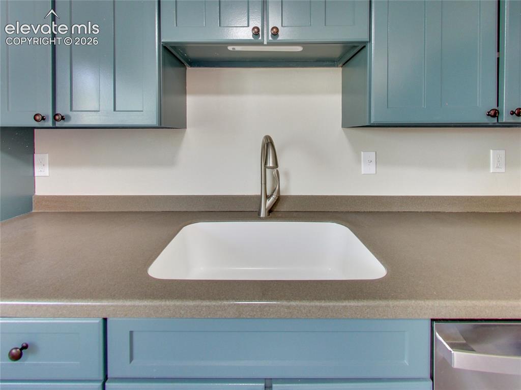 Image 8 of 32: Integrated sink with a high-arc faucet, solid surface countertop, and paint