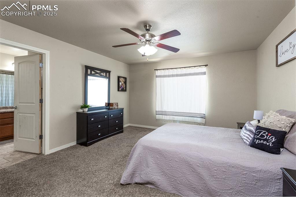 Image 13 of 33: Carpeted bedroom featuring baseboards and ceiling fan