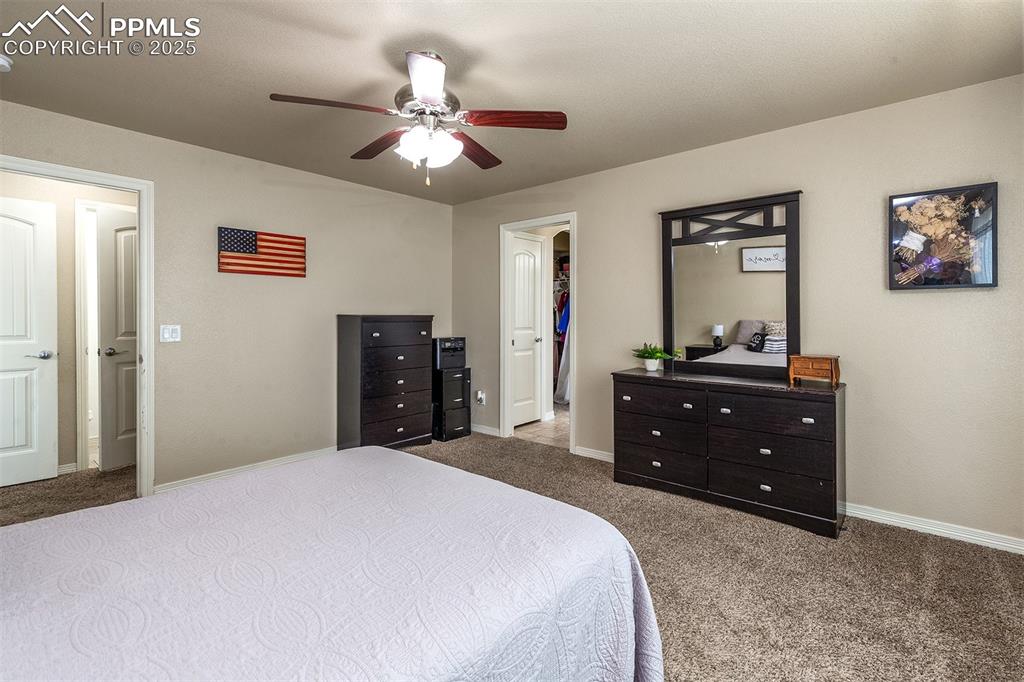 Image 14 of 33: Bedroom with carpet floors, a walk in closet, and ceiling fan