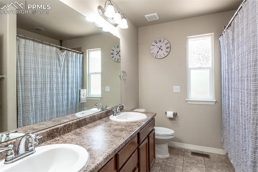 Image 15 of 33: Bathroom featuring healthy amount of natural light and double vanity