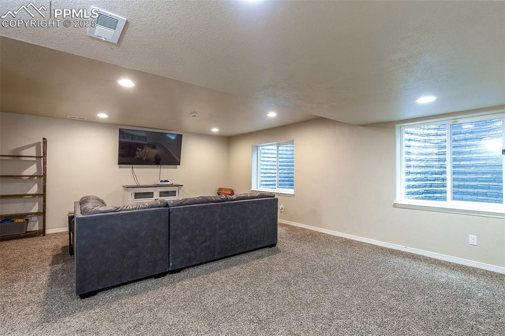 Image 25 of 33: Carpeted living room featuring recessed lighting and a textured ceiling