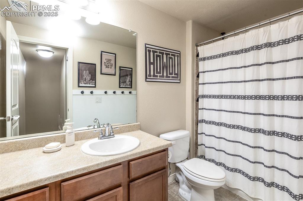 Image 28 of 33: Bathroom featuring vanity, tile patterned flooring, and curtained shower