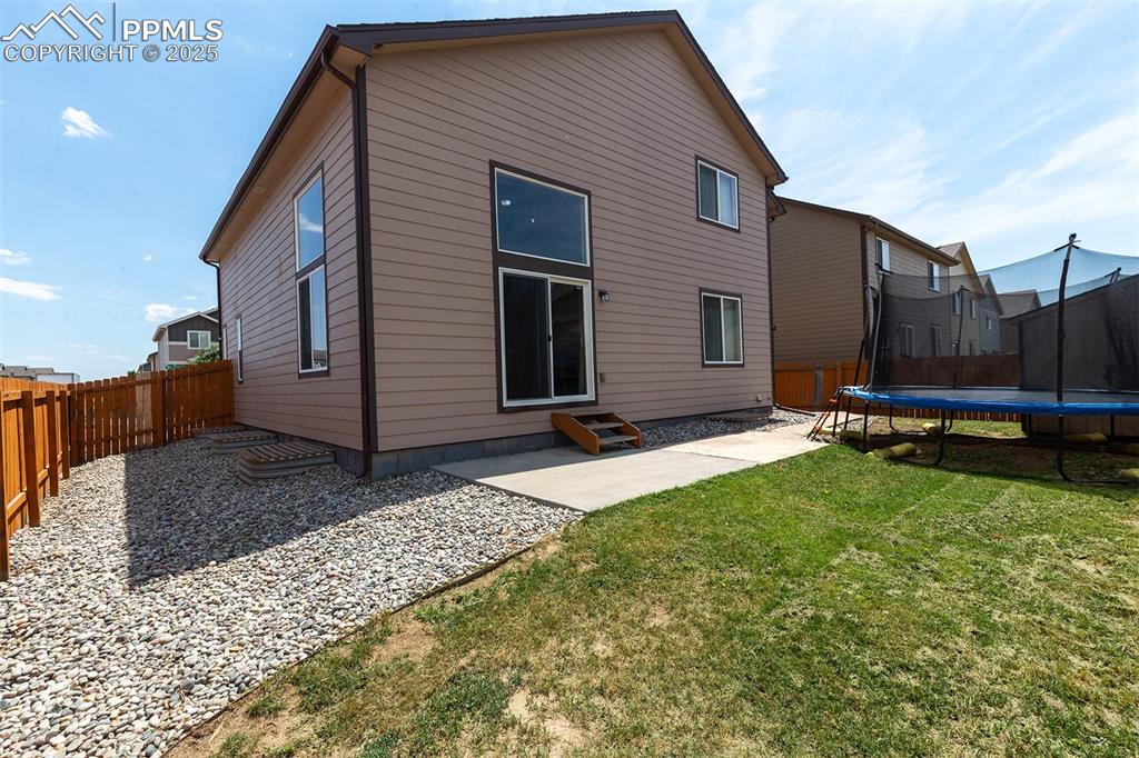 Image 31 of 33: Rear view of property featuring a trampoline, a patio area, a fenced backya