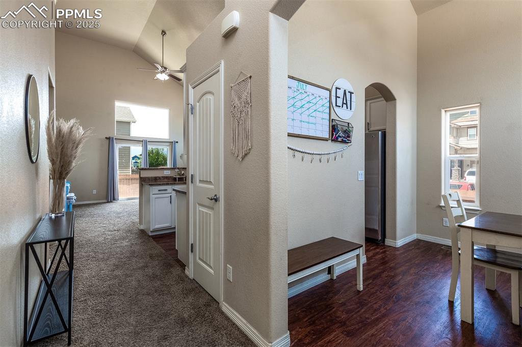 Image 4 of 33: Hallway with high vaulted ceiling, arched walkways, and dark wood-style flo