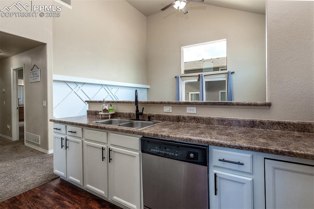 Image 9 of 33: Kitchen with dishwasher, dark countertops, a ceiling fan, lofted ceiling, a