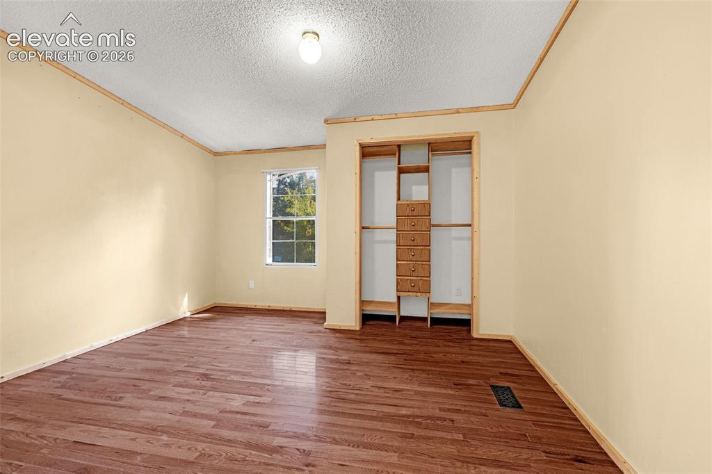 Image 14 of 27: Wood-finish flooring, built-in closet organization, fixed window, and a flu