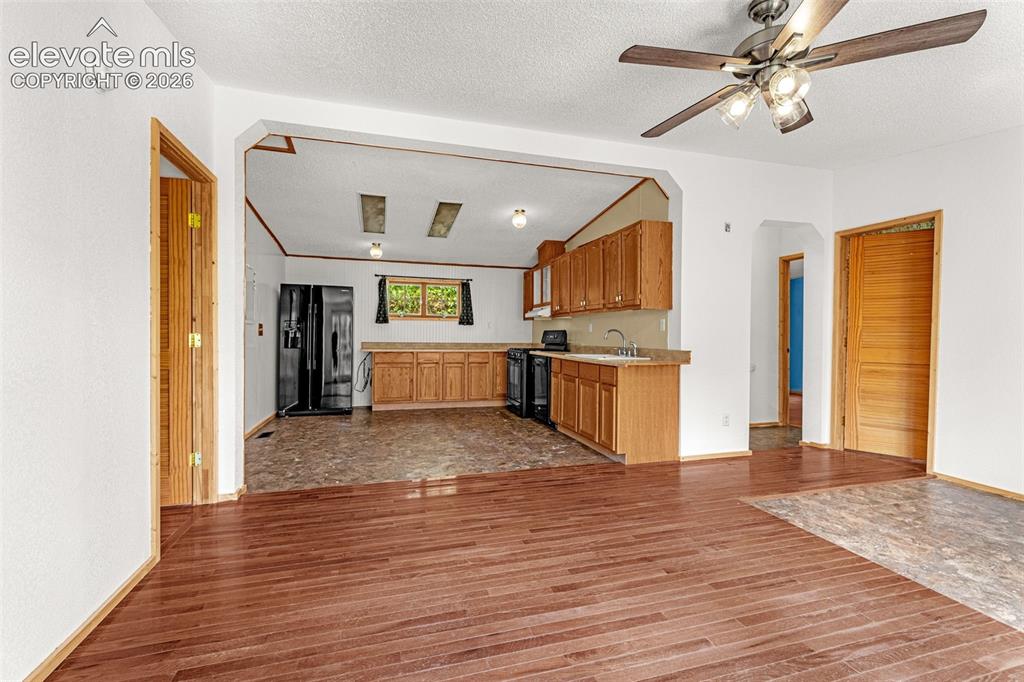 Image 5 of 27: Wood-finish flooring, overhead ceiling fan, natural wood cabinetry, and a b