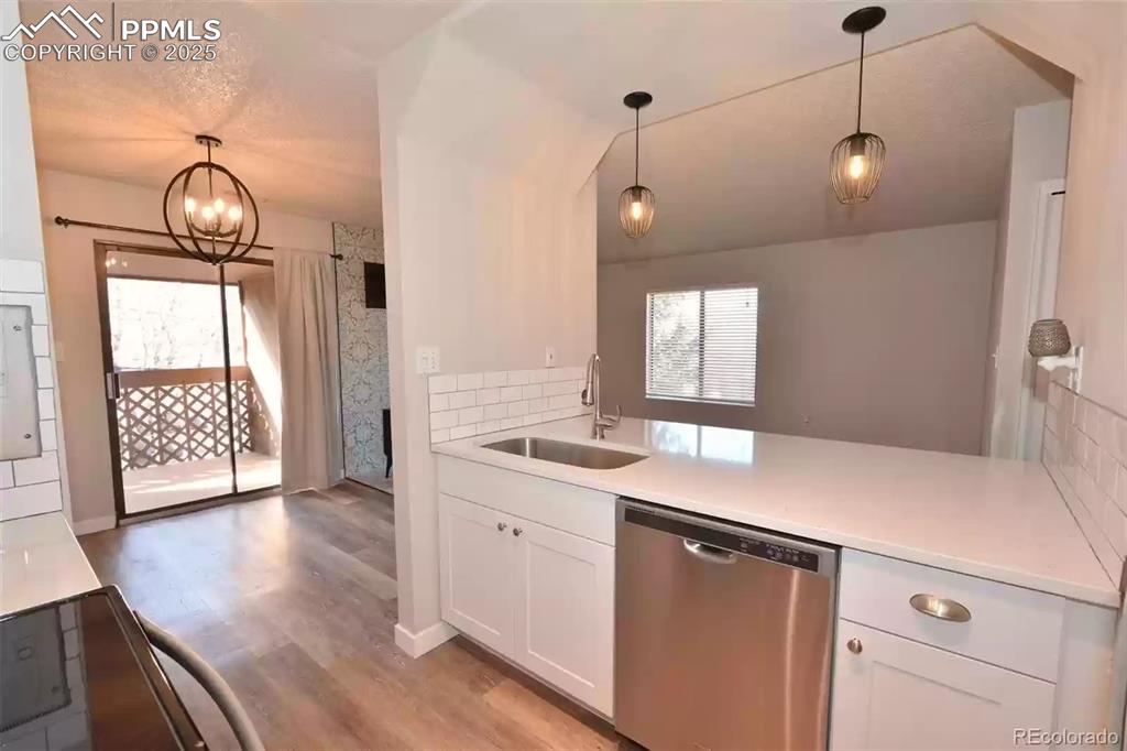 Image 12 of 28: Kitchen featuring dishwasher, pendant lighting, light wood-style flooring,