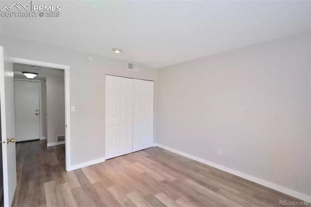 Image 18 of 28: Unfurnished bedroom featuring light wood-style flooring and a closet