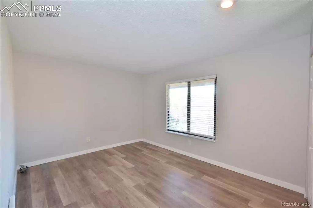 Image 19 of 28: Unfurnished room with light wood-style floors and a textured ceiling