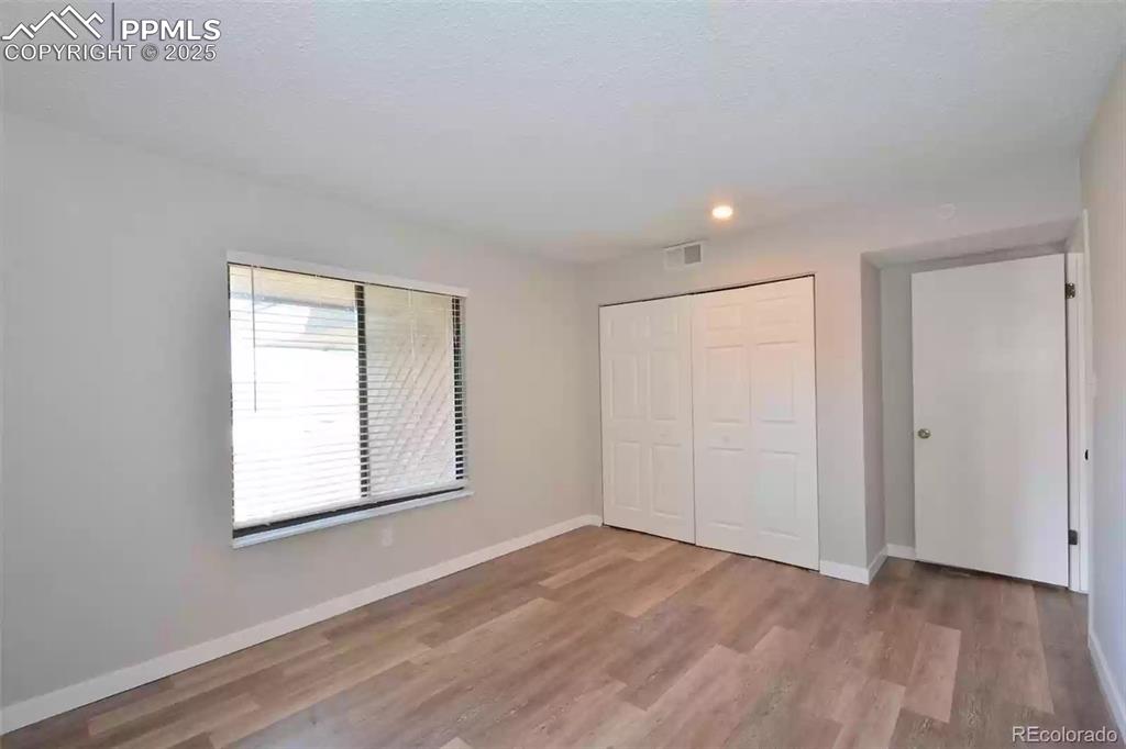 Image 20 of 28: Unfurnished bedroom featuring a closet, light wood-style floors, and recess