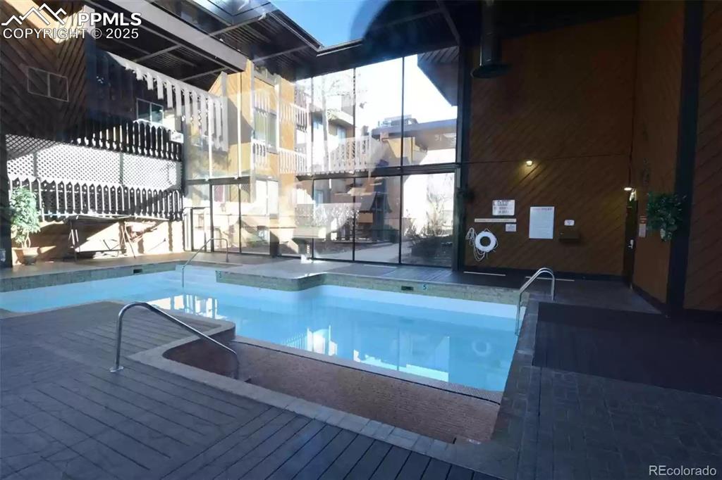 Image 26 of 28: Indoor community pool with a wooden deck