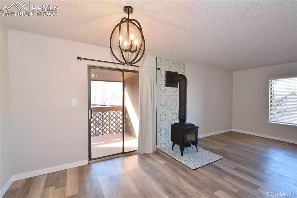 Image 9 of 28: Unfurnished dining area featuring a wood stove, plenty of natural light, wo