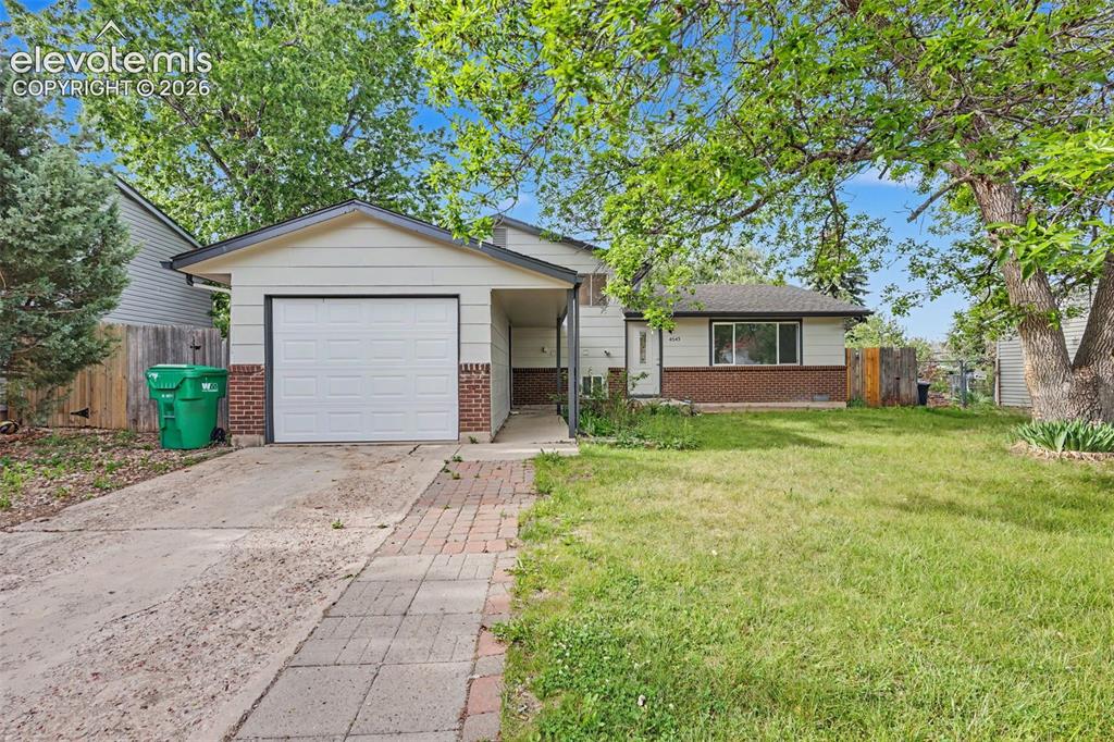 Image 1 of 32: Tri level home with attached garage and large front yard.