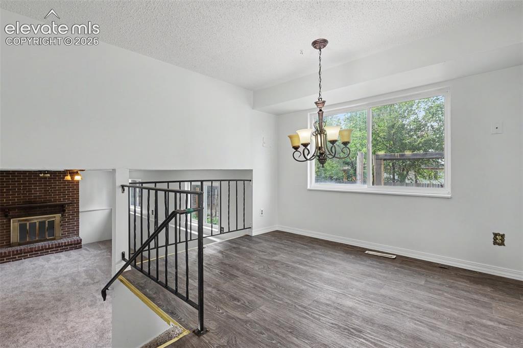 Image 10 of 32: Kitchen overlooking the dining area with chandelier lighting.