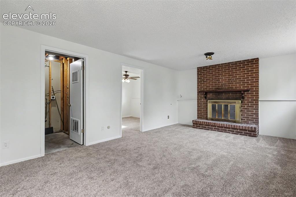 Image 12 of 32: Brick fireplace creates a warm focal point in the lower level family room.