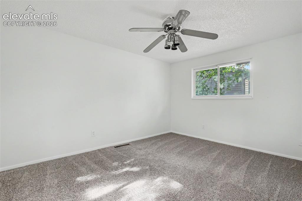 Image 16 of 32: Upper level bedroom with ceiling fan and new carpet.