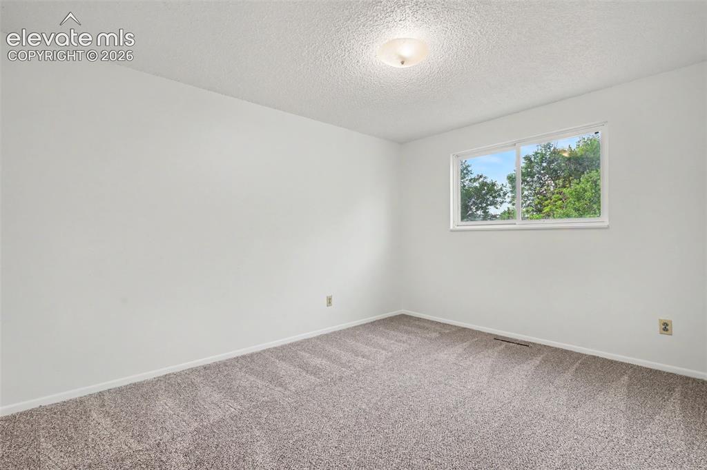 Image 19 of 32: Bright upper level bedroom with updated carpet and fresh paint.