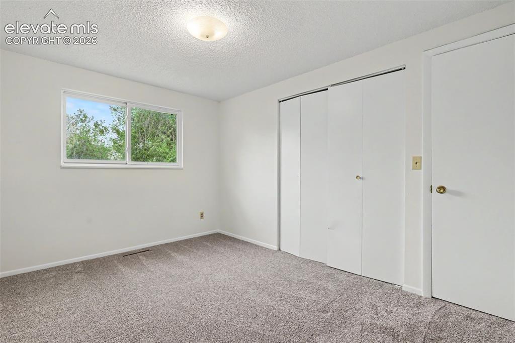 Image 20 of 32: Comfortable secondary bedroom with natural light.