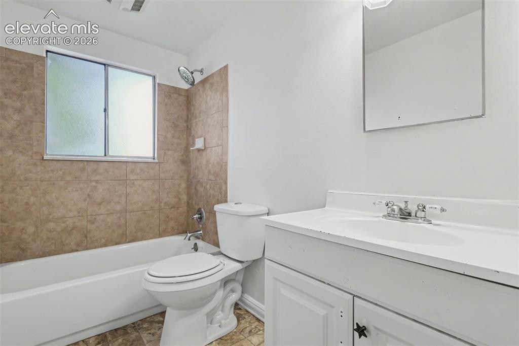 Image 23 of 32: Full upper level bathroom with tiled tub surround.