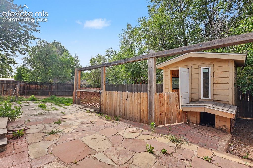 Image 25 of 32: Backyard includes a shed/playhouse and flexible outdoor space.