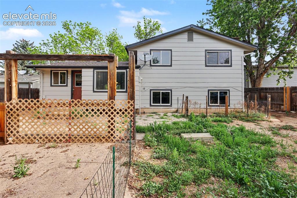 Image 27 of 32: Large backyard with garden space and mature trees.
