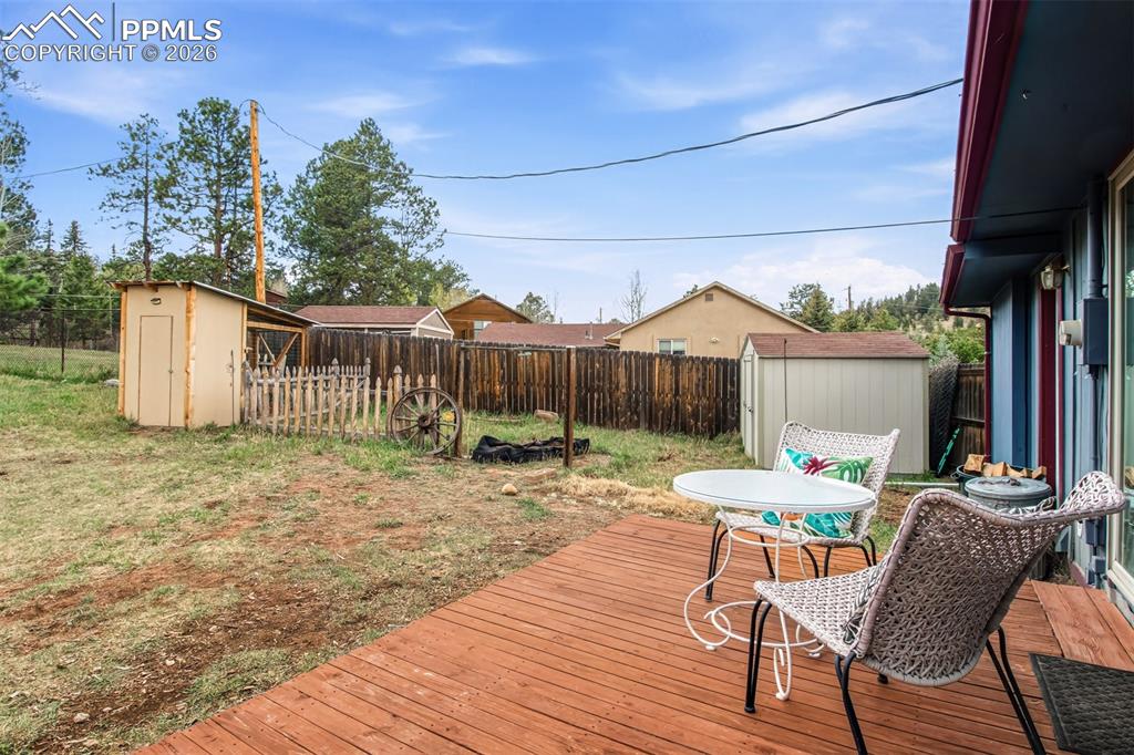Image 25 of 31: Back yard with 6 ft fence, fire pit, chicken coop and storage shed