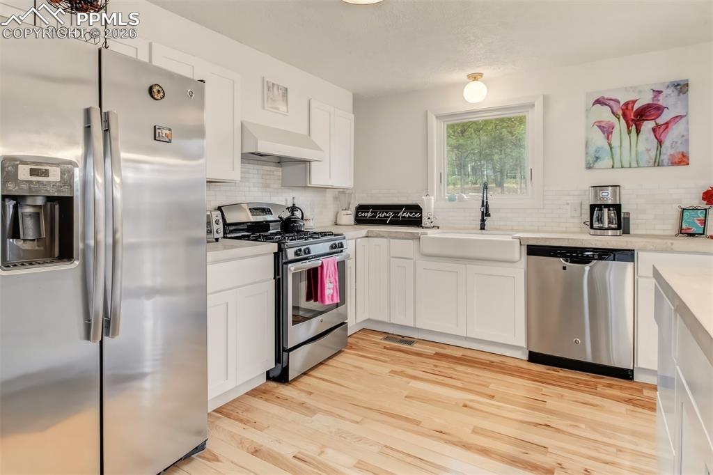 Image 8 of 31: Open concept farmhouse kitchen, with concrete countertops, matching applian