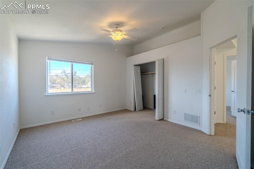 Image 12 of 36: Unfurnished bedroom featuring carpet floors, a ceiling fan, and a closet